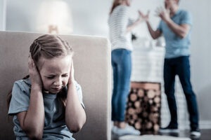 Too much stress. Little nervous girl closing her ears while hearing quarrels